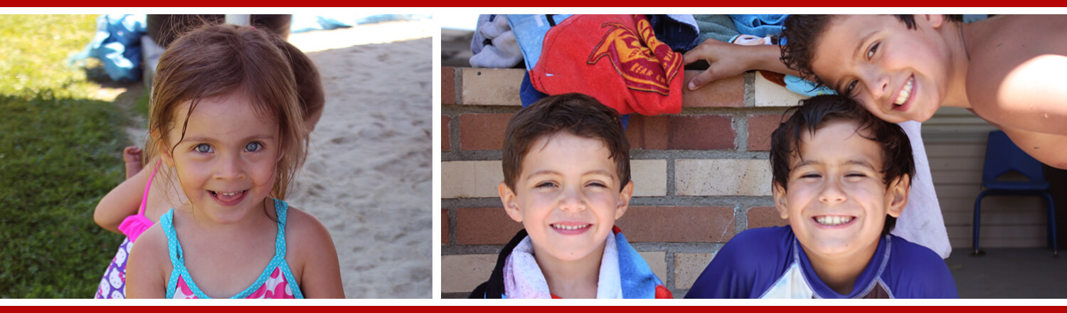 Children smiling outdoors in swimsuits.