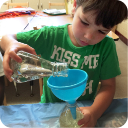 Child pouring liquid through a funnel.