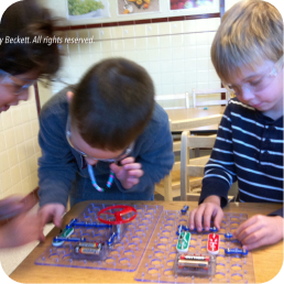 Children assembling an electronic circuit project.