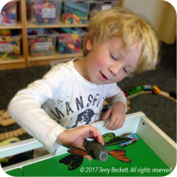 Child playing with toy on table.