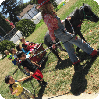 Children enjoy pony cart ride outdoors.