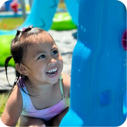Smiling child playing at a water park.