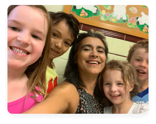 Smiling group selfie with children and adult.