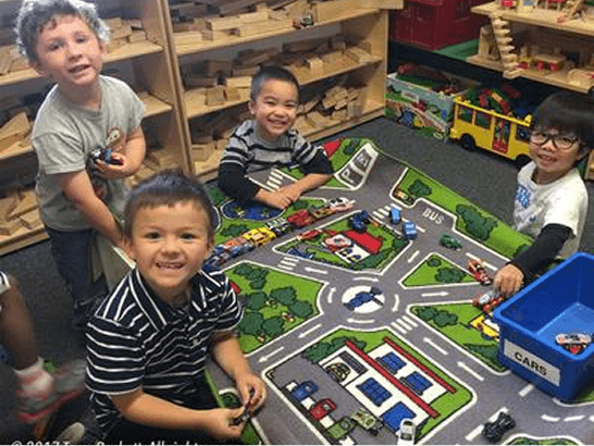 Children playing with toy cars indoors.