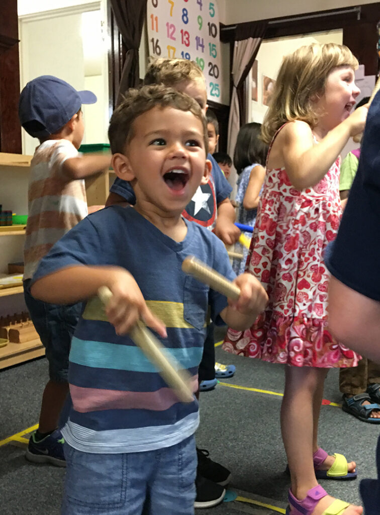Children playing and laughing in a classroom.