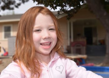 Smiling child in outdoor setting.
