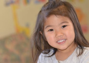 Young girl grinning in a playroom